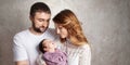 Woman and man holding a newborn. Mom, dad and baby.  Portrait of  smiling family with newborn on the hands. Happy family concept. Royalty Free Stock Photo