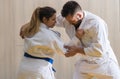 Woman and man judo fighters in sport hall