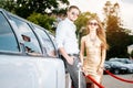 Woman and man leaning against a limo car Royalty Free Stock Photo