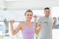 Woman and man lifting barbells at fitness studio Royalty Free Stock Photo