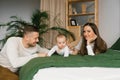 Woman and a man are lying on a bed with their baby son. Mom, Dad and baby, happy family at home Royalty Free Stock Photo