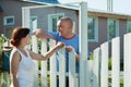 Woman and man near fence wicket