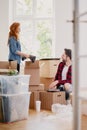 Woman and man packing stuff into carton boxes while moving out f Royalty Free Stock Photo