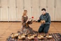 Woman and man playing on a tibetian singing bowl for sound therapy sitting in yoga studio Royalty Free Stock Photo