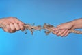 Woman and man pulling damaged rope on color background Royalty Free Stock Photo