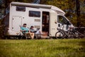 Woman with a man resting near motorhomes in nature. Family vacation travel, holiday trip in motorhome RV, Caravan car Vacation. Royalty Free Stock Photo