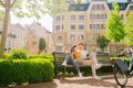 Woman and man resting on walk drinking coffee on bench