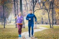 Woman and man running in autumn park for sport Royalty Free Stock Photo