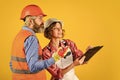 Woman and man safety hard hat. Discussing renovation with contractor. Redevelopment of home. Couple look documents Royalty Free Stock Photo