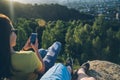 Woman with man sitting on the top of the hill injoy view on sunset