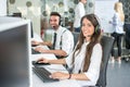 Woman and man telephone operators with headsets working on desktop computer in customer service call support center Royalty Free Stock Photo