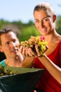 Woman and man working with grape harvesting machine