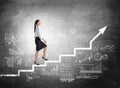 Businesswoman going up on stairs, blackboard with graph and charts Royalty Free Stock Photo