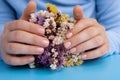 Woman manicured hands, stylish beige nails. Closeup of manicured nails of female hand in blue sweater in blue background Royalty Free Stock Photo