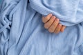 Woman manicured hands, stylish beige nails. Closeup of manicured nails of female hand in blue sweater in blue background Royalty Free Stock Photo