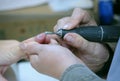 Woman manicurist hands removing cuticles from clients nails using cuticle pusher Royalty Free Stock Photo