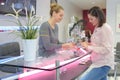 Woman manicurist trims cuticles on nails client