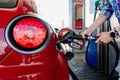 Woman manually filling a car with gasoline, oil, fuel at a refueling station. Royalty Free Stock Photo