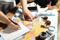 Woman marking calendar at table with world map. Travel during summer vacation