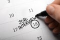 Woman marking date of job interview in calendar