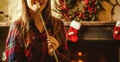 Woman with marshmallow by the fireplace. Young woman smiling and