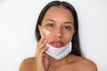 Woman with mask applying moisturizing facial cream. Concept of beauty and skin care