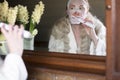 a woman in a mask brushing her teeth with an electric toothbrush Royalty Free Stock Photo