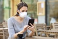 Woman with mask checking news on phone