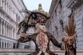 Woman in mask and costume with birdcage, Bridge of Sighs in the background, during the Venice Carnival Royalty Free Stock Photo