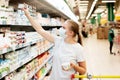 A woman in a mask makes purchases in a supermarket. Royalty Free Stock Photo