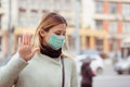 Woman in mask, making stop sign gesture with hand