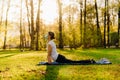 Woman with mask meditating/practicing yoga in nature alone.Social distancing and active healthy lifestyle. Mindfulness meditation.