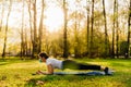 Woman with mask meditating/practicing yoga in nature alone.Social distancing and active healthy lifestyle. Mindfulness meditation.