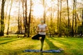 Woman with mask meditating/practicing yoga in nature alone.Social distancing and active healthy lifestyle. Mindfulness meditation.