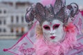 Woman in mask and ornate pink jester`s costume at Venice Carnival Carnivale di Venezia Royalty Free Stock Photo