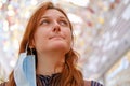 A woman with a mask removed after the end of the coronavirus quarantine, a close-up portrait of a red-haired girl. Copy space for Royalty Free Stock Photo