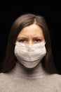 A woman in a mask , a tense, restless look at the camera. concern about a coronavirus infection , an attempt at