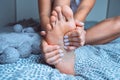 Woman massaging tired painful foot in bed. Feet pain leg cramps, pain in legs or muscle spasm Royalty Free Stock Photo