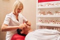 Woman massagist doing scratching movement during face massage