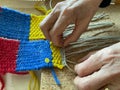 A woman master weaver weaving the tapestry with diverse bright threads, hands closeup. Artisanal at work handcraft concept