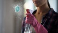 Woman masterfully struggling with stains on glass, using new cleaning agent Royalty Free Stock Photo