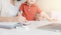 Woman on maternity leave working home online with laptop in kitchen with small child. Concept mom work while in Royalty Free Stock Photo