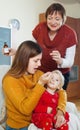 Woman with mature mother caring for sick toddler