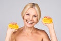 Woman mature with perfect skin, squeezing oranges Royalty Free Stock Photo