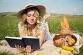 Woman in a meadow reads a book. picnic, countryside. milk and bakery products Royalty Free Stock Photo