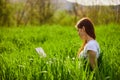 woman on the meadow relaxing and using a laptop Royalty Free Stock Photo