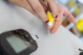 Woman measures diabetes with glucometer.Close up on hands while pricking finger