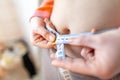 Woman measures her abdomen with a measuring tape