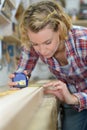 woman measures wood plank before saw Royalty Free Stock Photo