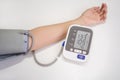 Woman measuring blood pressure with electronic digital tonometer, female hand close up. Arterial hypotension and cardiology Royalty Free Stock Photo